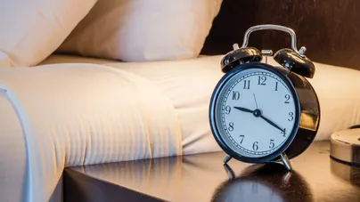 An alarm clock sitting on a bedside table.