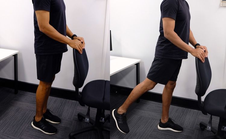A man using a chair for support while doing standing backwards kicks.