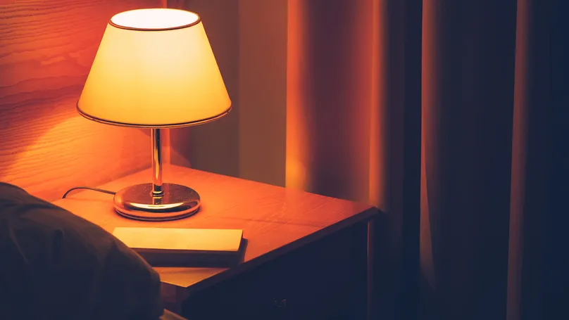 Image of a dark but warmly lit bedroom.