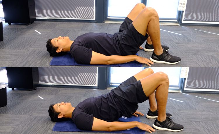 A man on the floor doing a hip bridge exercise.