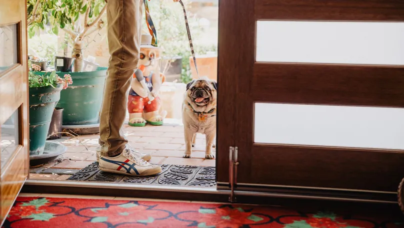 Salvador walks his dog through the front door