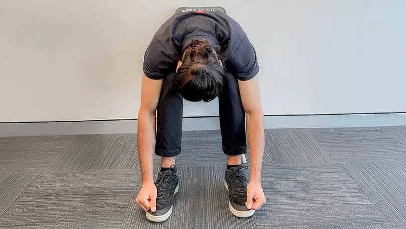 Image of man doing forward fold seated