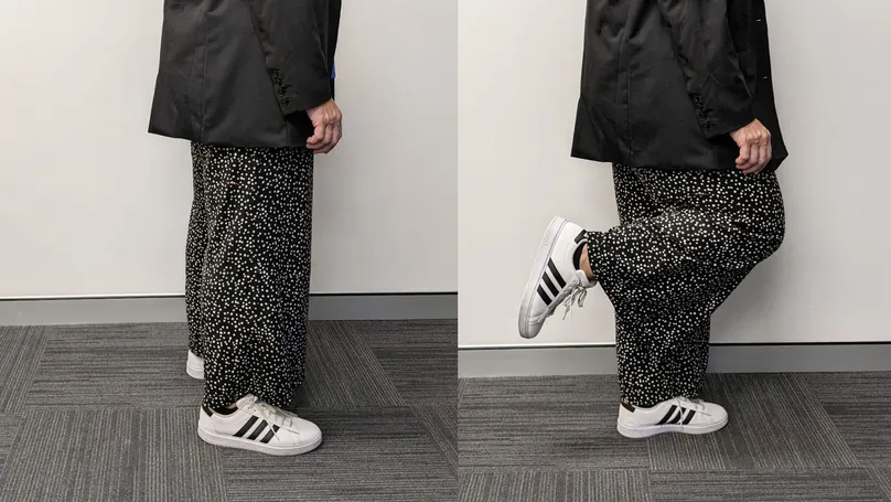 A woman doing backwards knee extensions while standing.