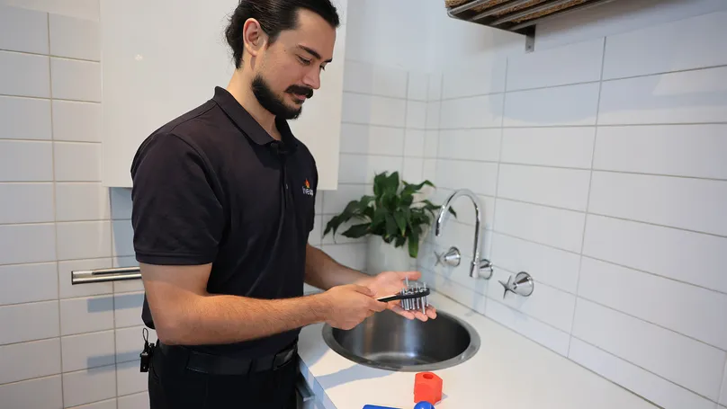 Man holding tap turner in the bathroom