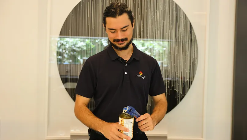 Man using can opener in the kitchen