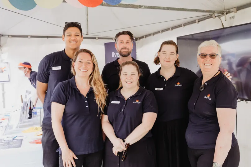 Photo of six members of LiveUp staff, smiling, at an event