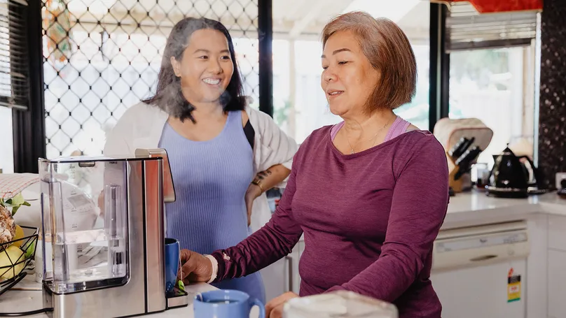 Myra and her daughter using the coffee machine.