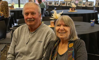 Image of an older couple smiling while sitting together at a table