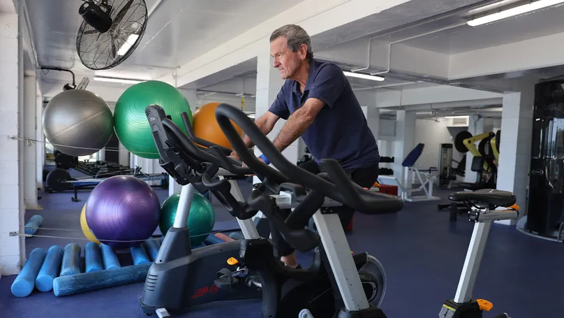 Older men on exercise bike in gym