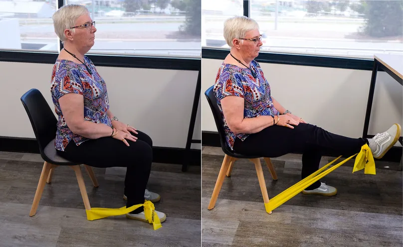 A woman doing a seated leg extension with a resistance band.