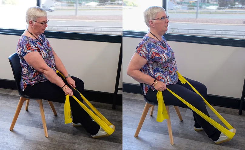 A woman doing a seated row with a resistance band.