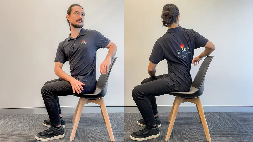 A man doing a spinal twist while seated.