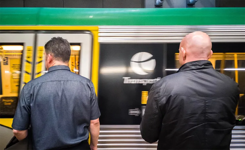 Image of Transperth train speeding past while people wait to board