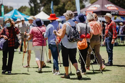 Image of older people using hiking sticks outside.