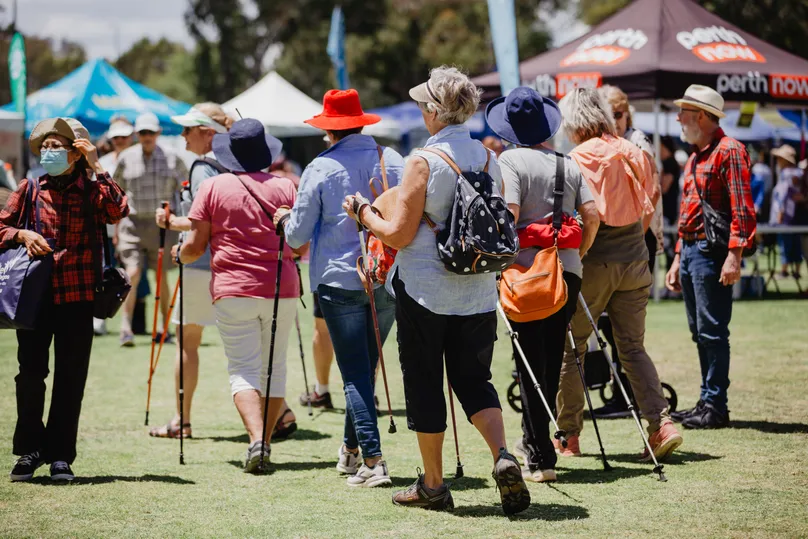 Image of older people using hiking sticks outside.