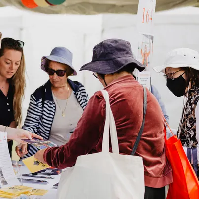 A woman carrying tote bags on her shoulders.