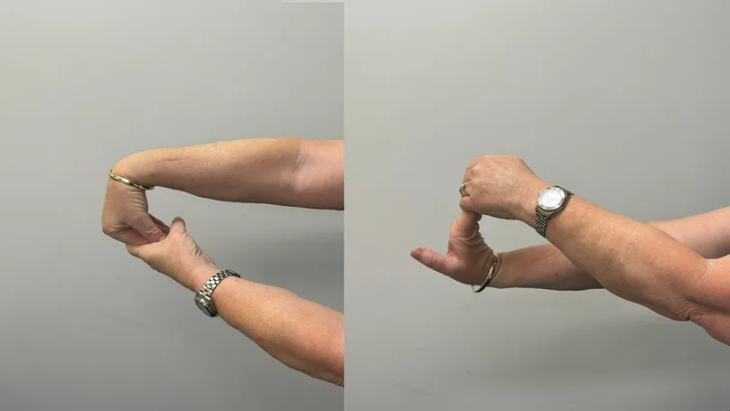 A woman's hands doing wrist and forearm stretches.