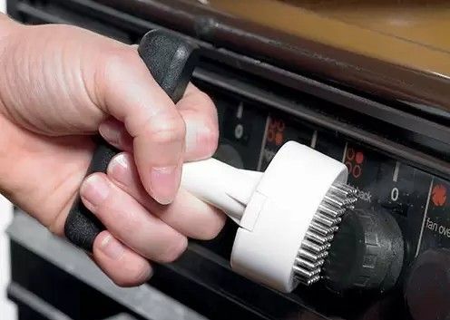 A hand using a contour turner to turn an oven dial.