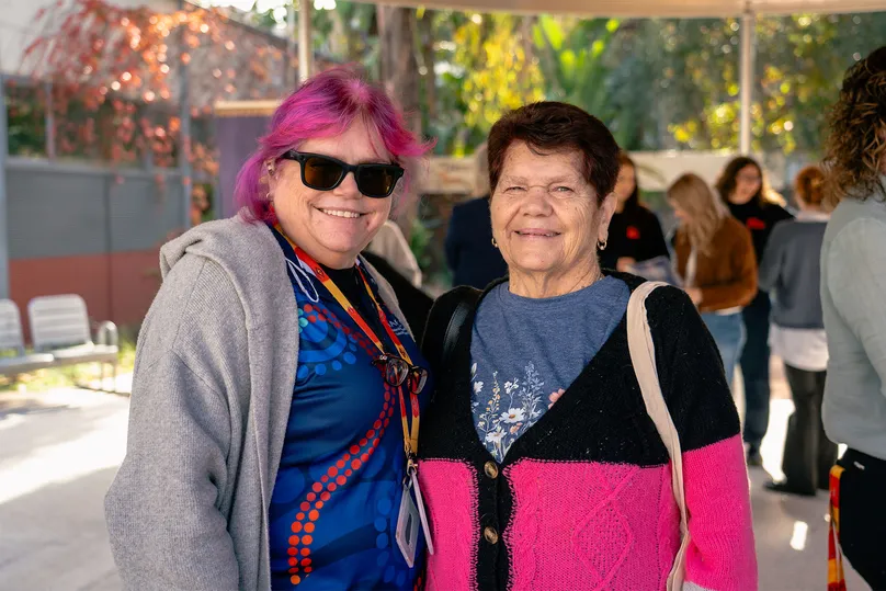 Two first nations women smiling at the camera.
