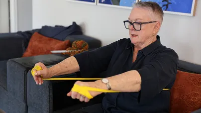 older woman using resistance bands sitting