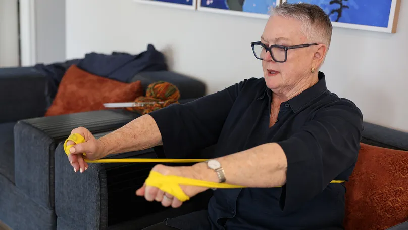 older woman using resistance bands sitting