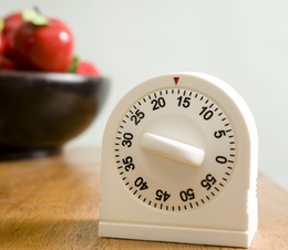 A small dial timer on a kitchen bench.