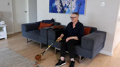 Woman using reacher in living room
