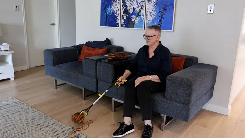 Woman using reacher in living room